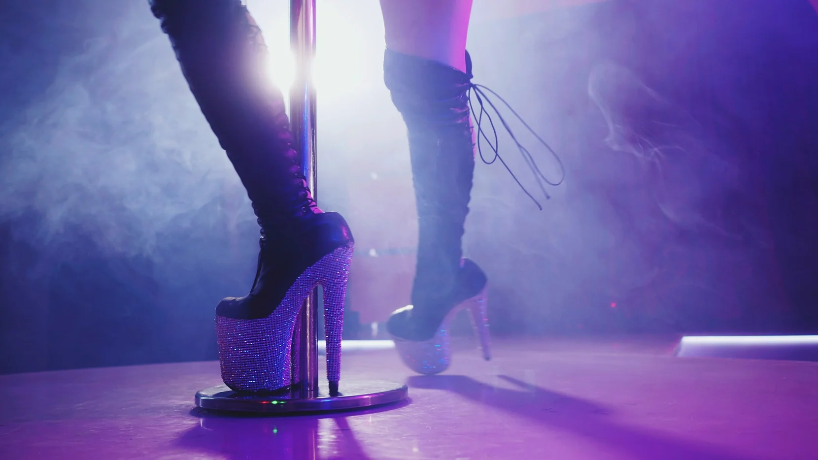 Purple-lit stage and dancer in platform boots